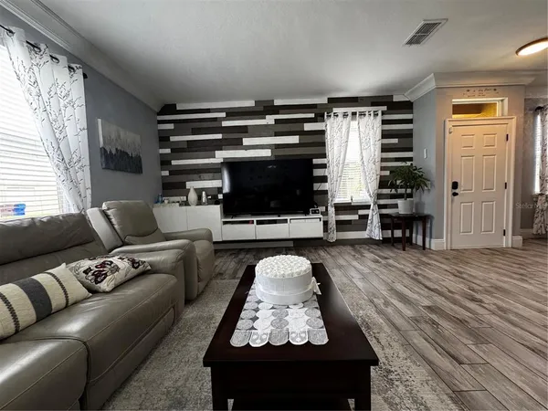a living room with furniture and wooden floor