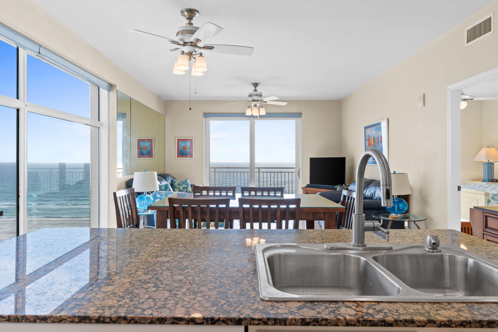 12011 Front Beach Road, Unit 201C Panama City Beach, FL 32407 - Photo 2 of 42 a kitchen with a sink a dining table and chairs