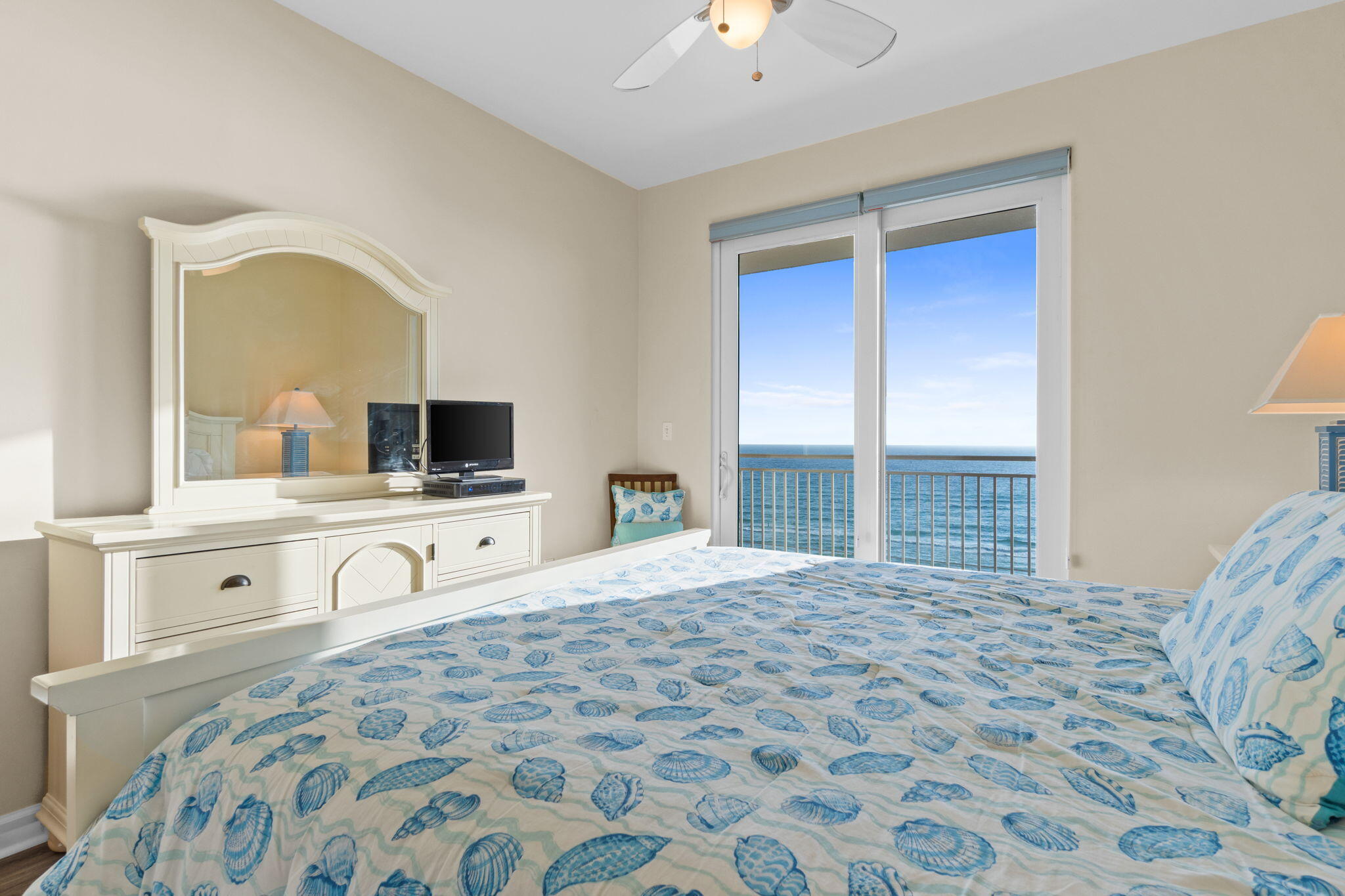 12011 Front Beach Road, Unit 201C Panama City Beach, FL 32407 - Photo 9 of 42 a large bedroom with a bed and a flat tv screen on dresser