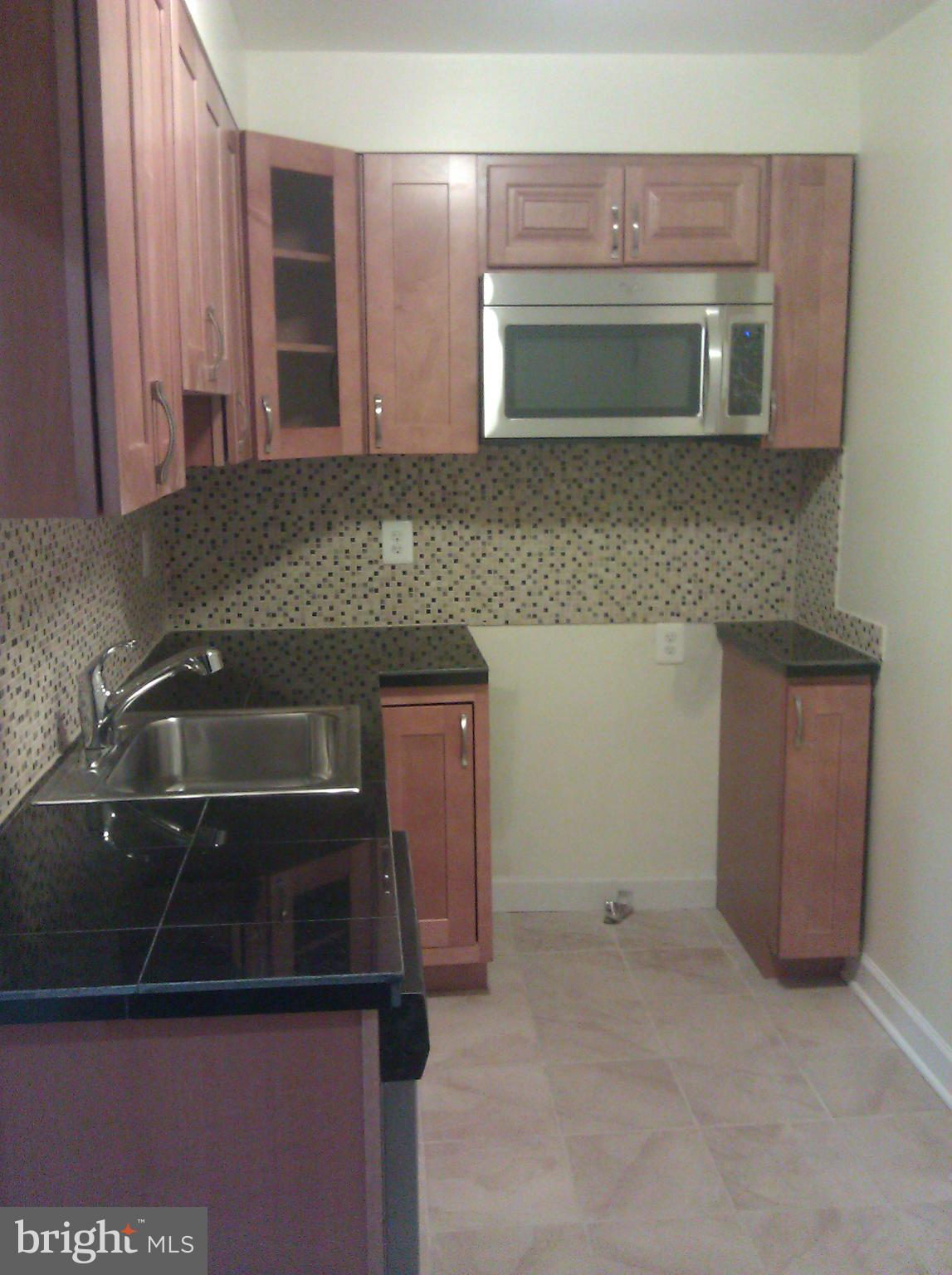 148 West Edgevale Road Baltimore, MD 21225 - Photo 3 of 12 a kitchen with a sink and cabinets