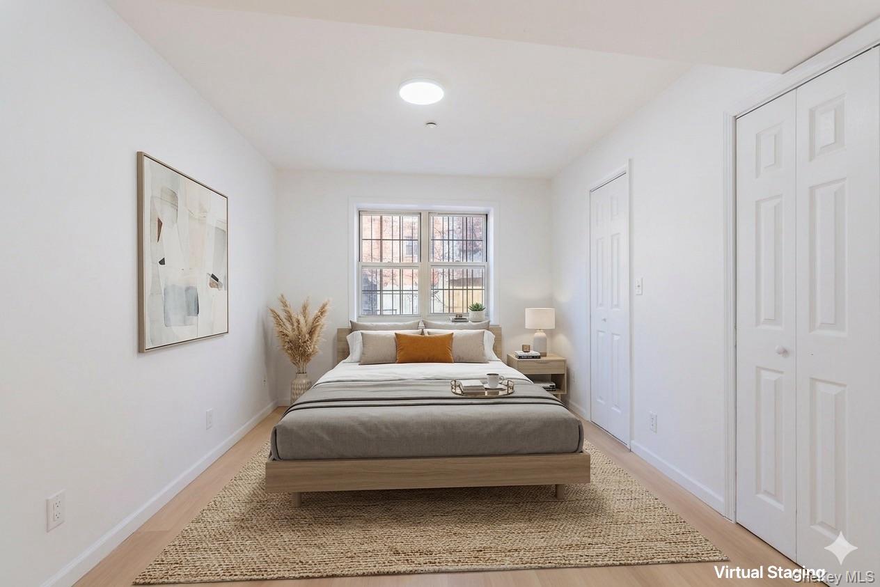 102-23 43rd Avenue, Unit 1B Queens, NY 11368 - Photo 11 of 18 a bedroom with a bed and window