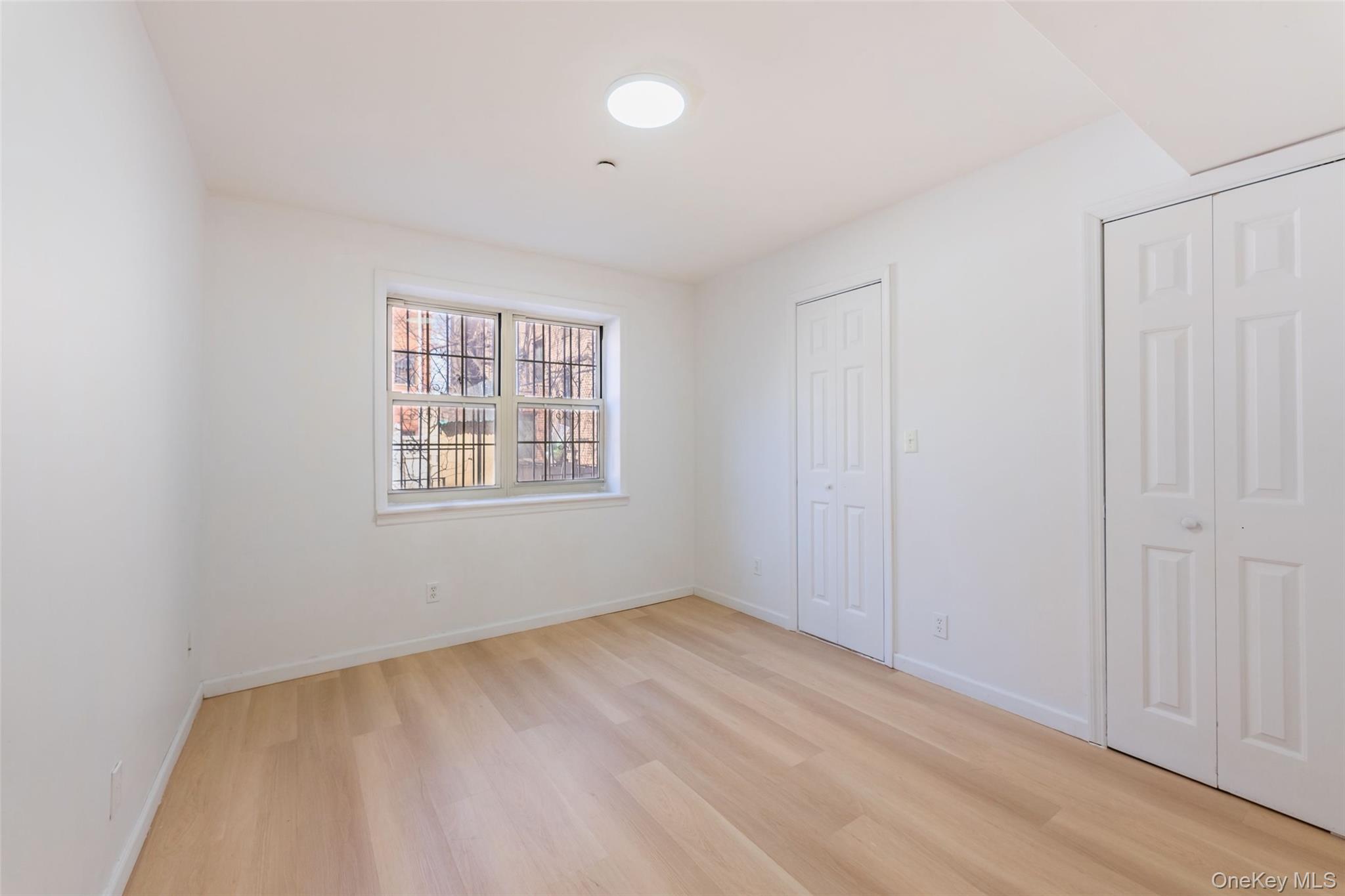 102-23 43rd Avenue, Unit 1B Queens, NY 11368 - Photo 12 of 18 an empty room with windows