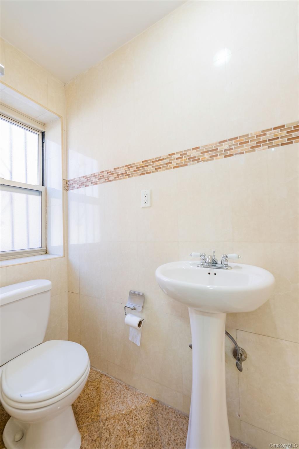 102-23 43rd Avenue, Unit 1B Queens, NY 11368 - Photo 13 of 18 a bathroom with a sink toilet and shower
