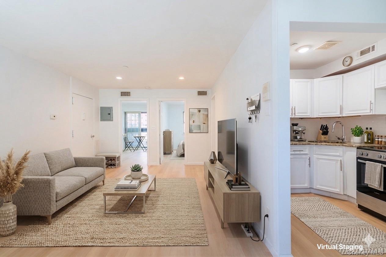 102-23 43rd Avenue, Unit 1B Queens, NY 11368 - Photo 3 of 18 a living room with furniture flat screen tv and refrigerator