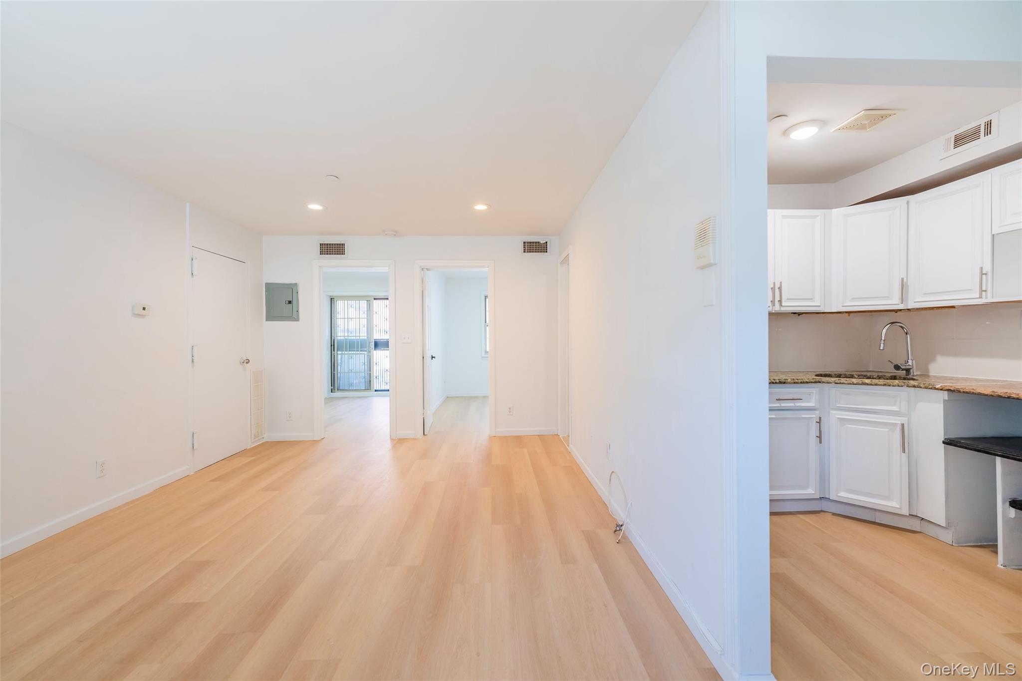 102-23 43rd Avenue, Unit 1B Queens, NY 11368 - Photo 4 of 18 a view of a kitchen with a sink and dishwasher a refrigerator with white cabinets