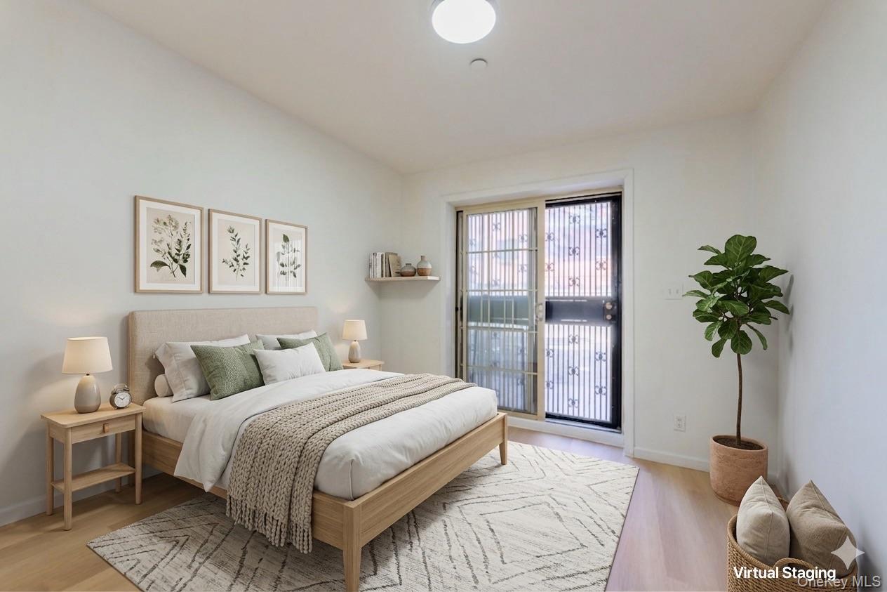 102-23 43rd Avenue, Unit 1B Queens, NY 11368 - Photo 9 of 18 a bedroom with a large bed and a potted plant
