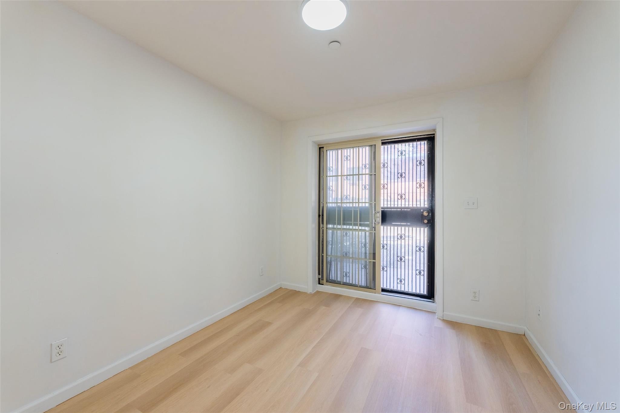 102-23 43rd Avenue, Unit 1B Queens, NY 11368 - Photo 10 of 18 an empty room with wooden floor and windows