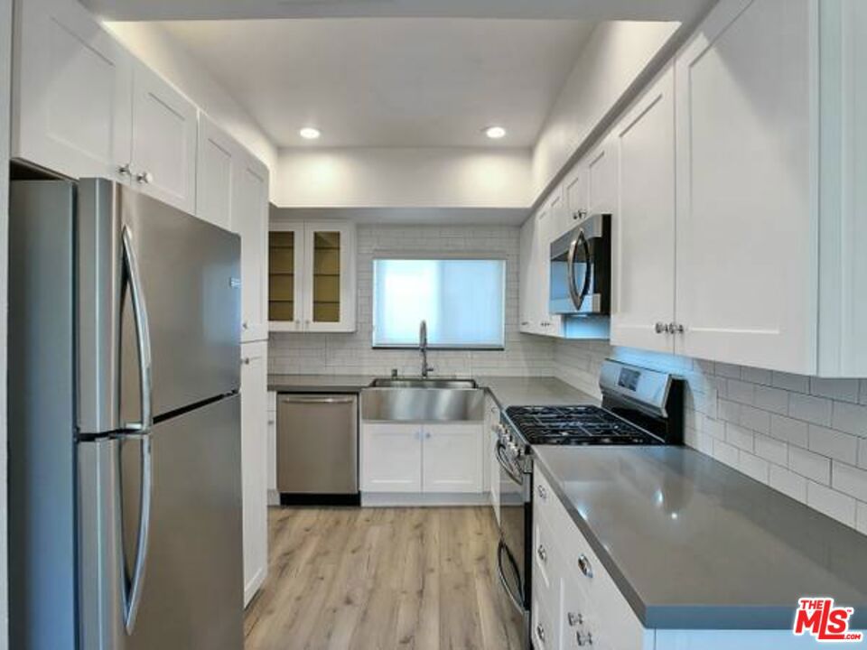 1900 Silver, Unit 104 Los Angeles, CA 90039 - Photo 6 of 21 a kitchen with a refrigerator a sink and white cabinets