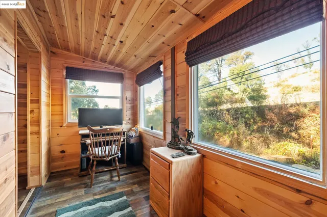 a dining room with furniture large windows wooden floor and garden view