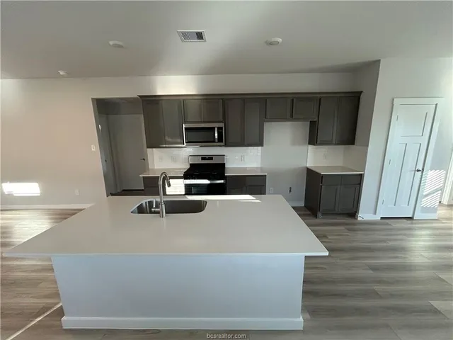 a kitchen with stainless steel appliances a refrigerator and a stove top oven
