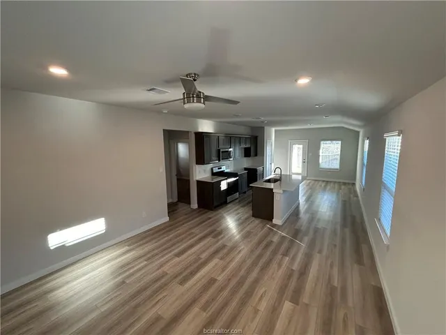 a view of a living room a kitchen and a sink
