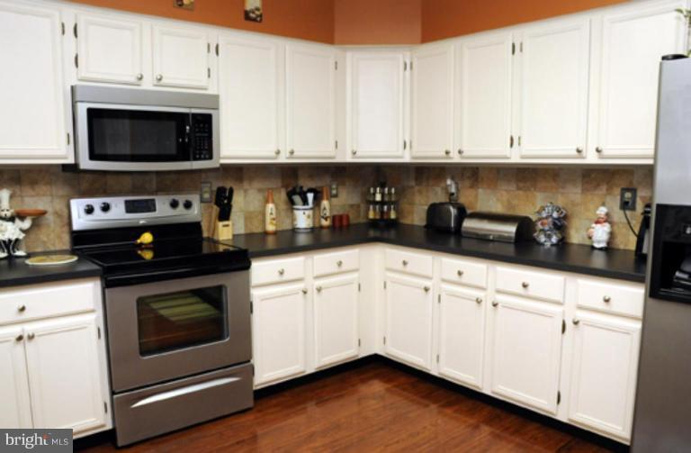 819 Sunny Chapel Road Odenton, MD 21113 - Photo 13 of 26 a kitchen with stainless steel appliances granite countertop white cabinets a sink and dishwasher