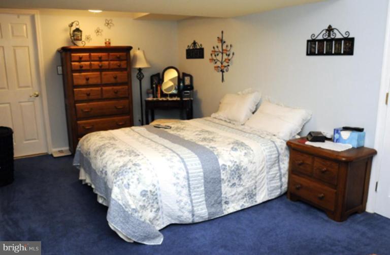 819 Sunny Chapel Road Odenton, MD 21113 - Photo 20 of 26 a bed sitting in a bedroom next to a window and dresser