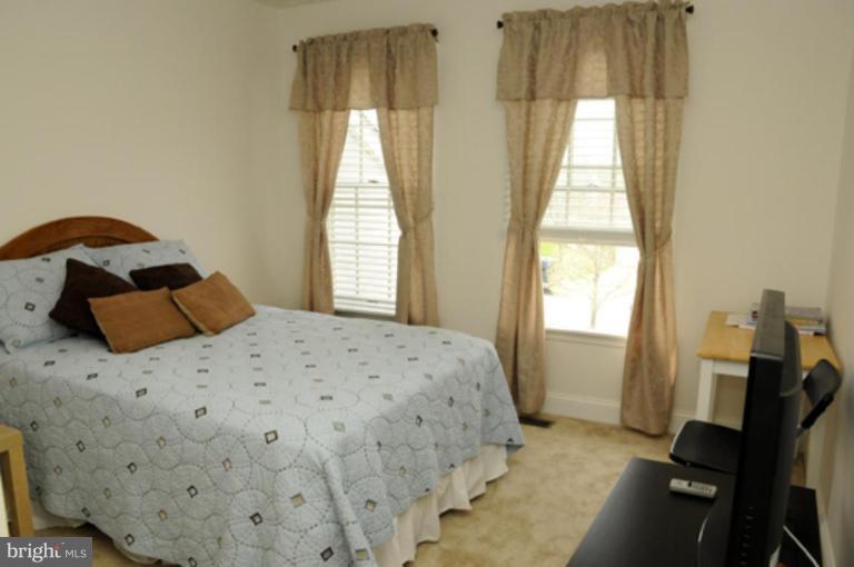 819 Sunny Chapel Road Odenton, MD 21113 - Photo 4 of 26 a bedroom with a bed and wooden floor