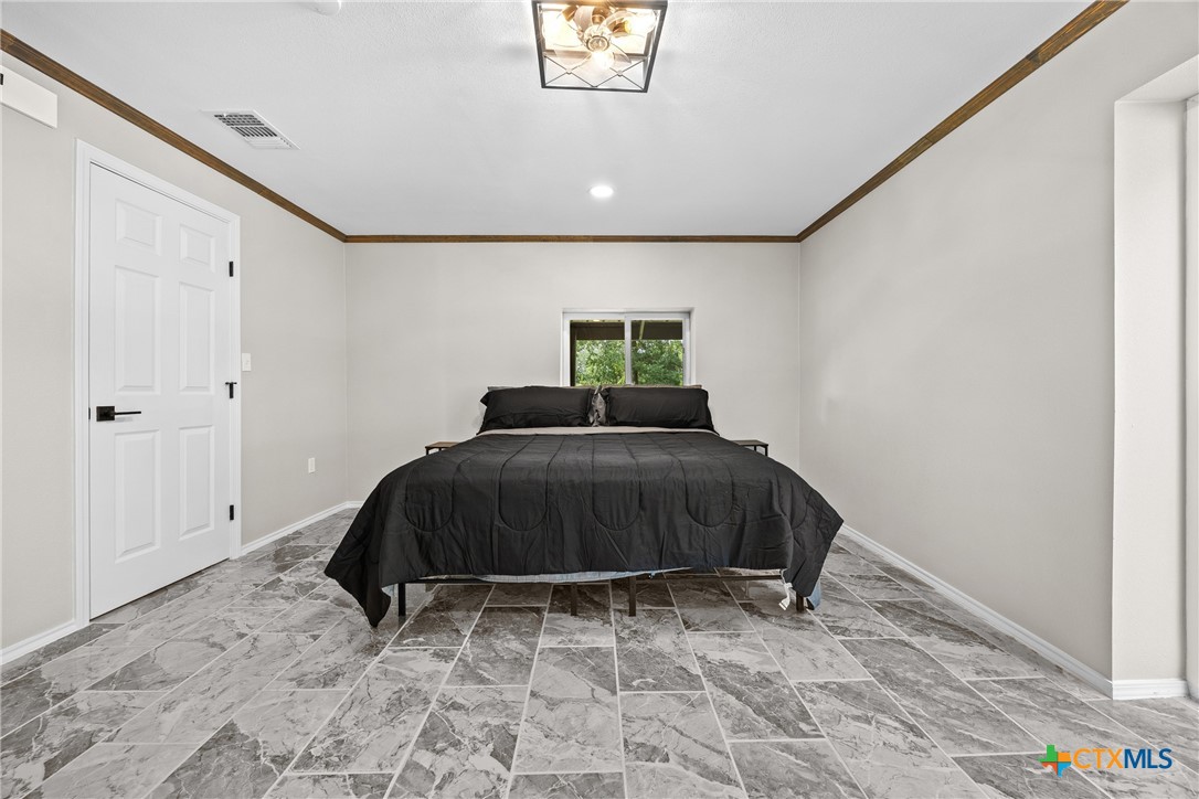 115 Spotted Fawn Gatesville, TX 76528 - Photo 23 of 38 a bedroom with a bed and a dresser
