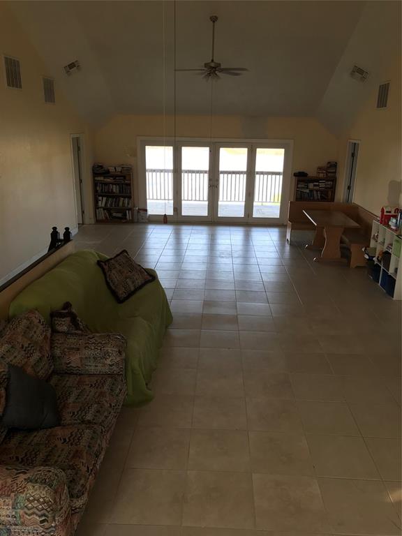 1100 East Rabbit Cove Road Quinlan, TX 75474 - Photo 6 of 18 Living room featuring healthy amount of natural light, light tile patterned flooring, ceiling fan, and high vaulted ceiling