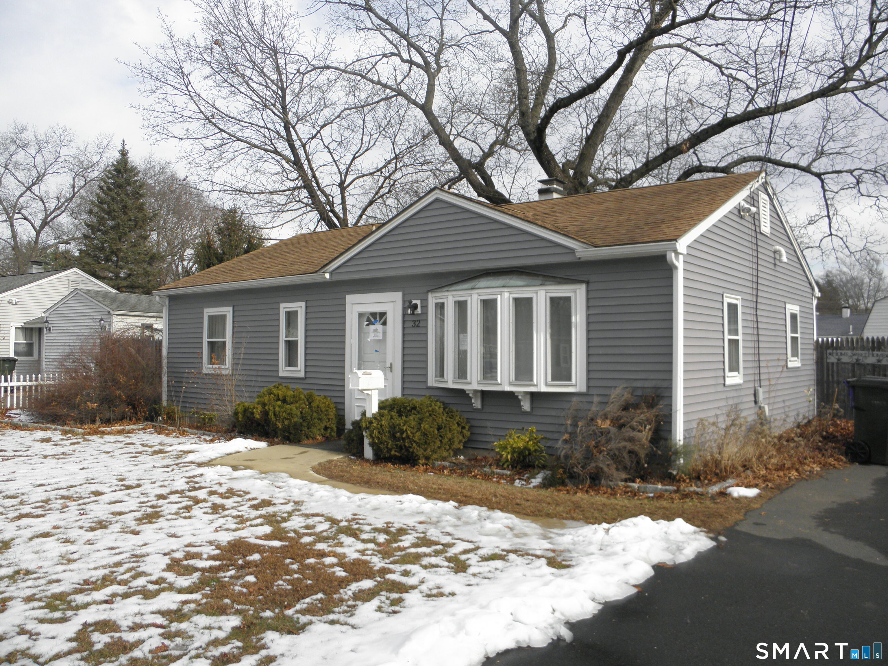 a front view of a house with a yard and tree s