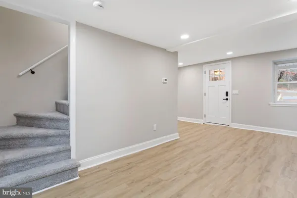 a view of an empty room with wooden floor and windows