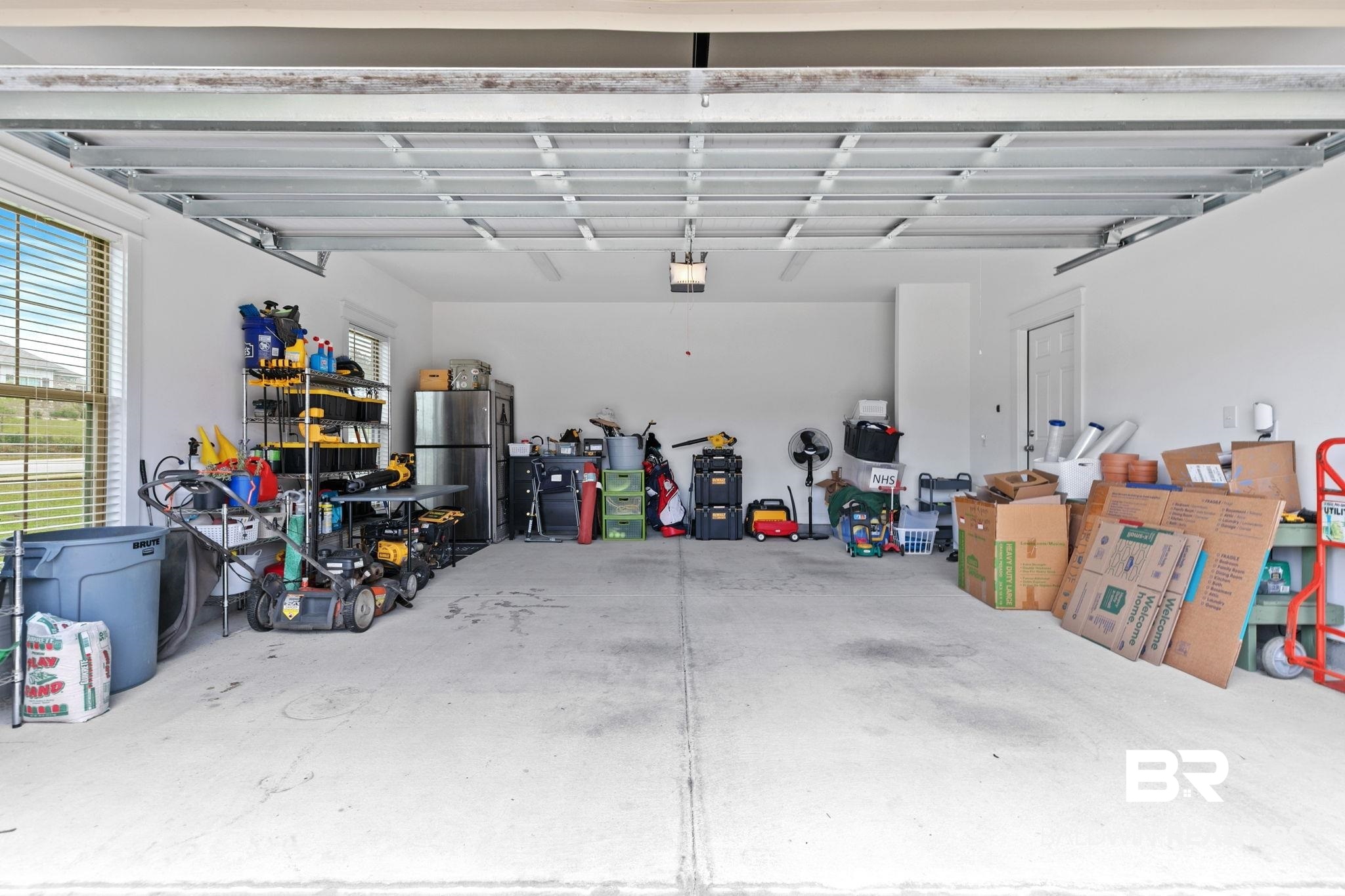 13233 Ibis Boulevard Daphne, AL 36527 - Photo 77 of 100 Spacious two-car garage with a concrete floor, white painted walls, window with blinds, and recessed lighting