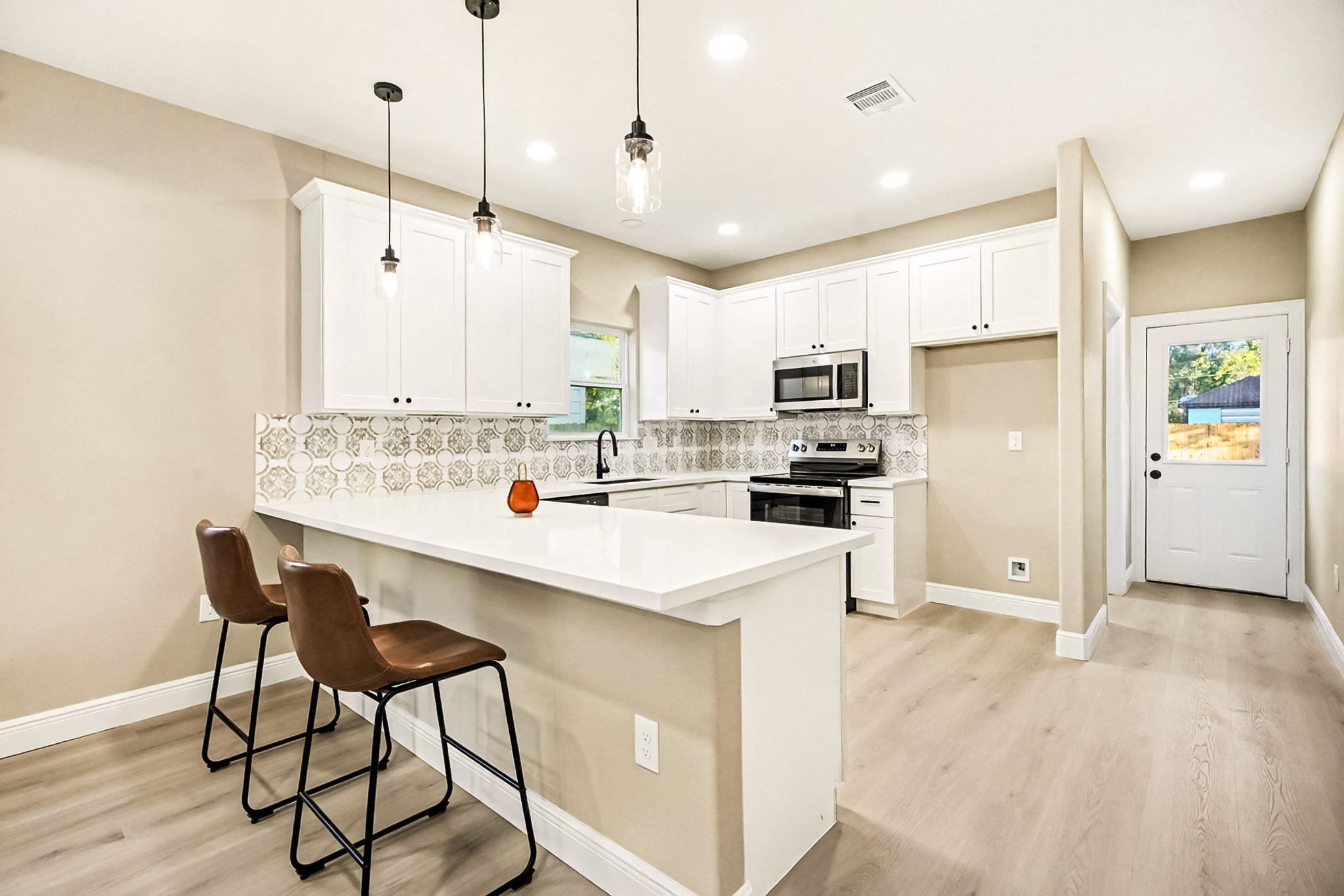 2008 Bellview Street La Marque, TX 77568 - Photo 9 of 17 a kitchen with kitchen island a stove a table a sink and a refrigerator