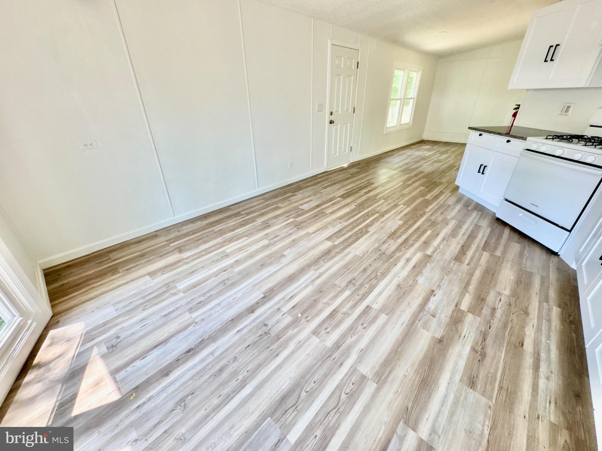 448 Evergreen Road Millville, NJ 08332 - Photo 10 of 25 a view of kitchen and empty room with wooden floor