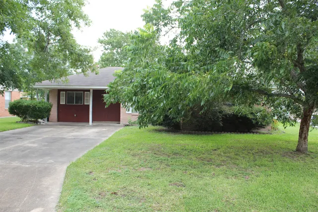 a front view of a house with a yard and trees