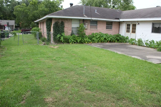 a view of a house with a yard and potted plants