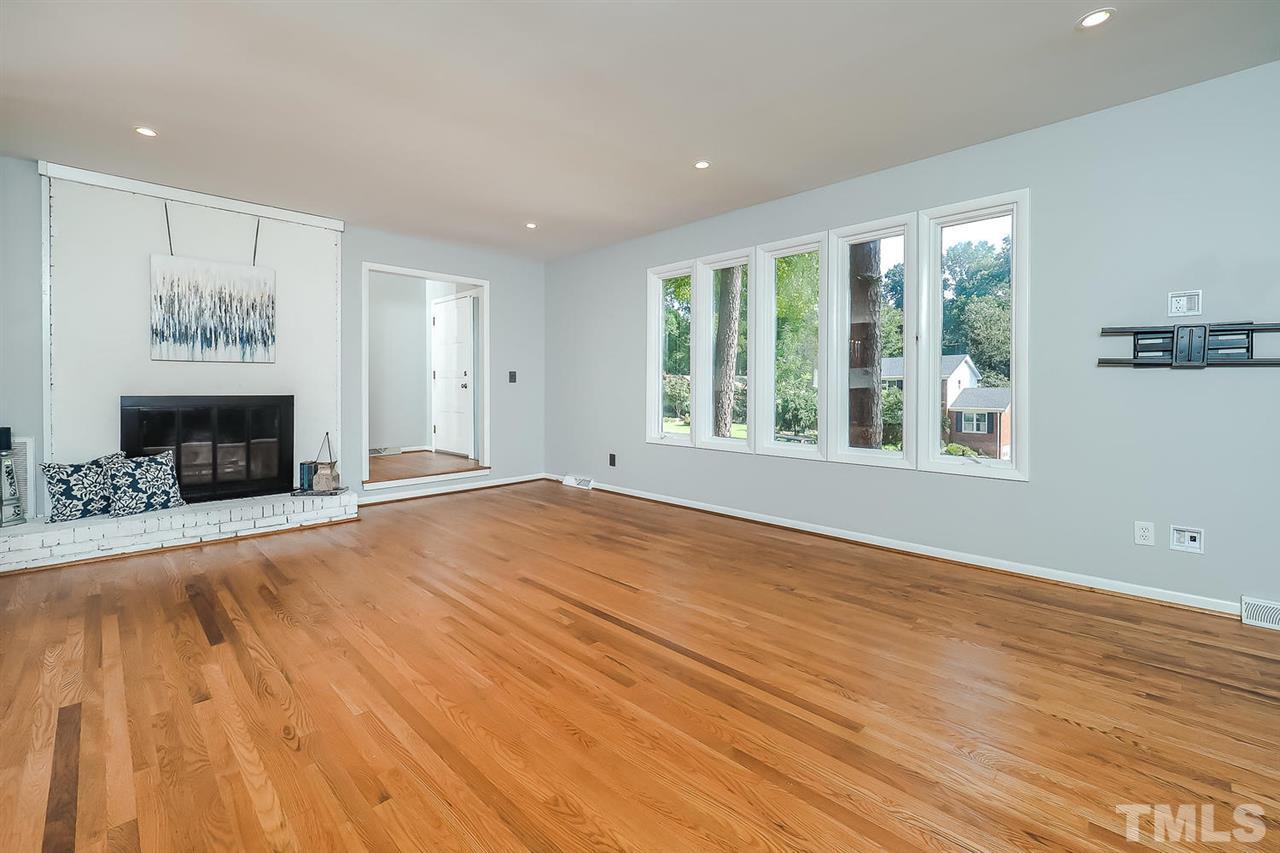6233 Rushingbrook Drive Raleigh, NC 27612 - Photo 11 of 12 Living room offers gorgeous hardwood floors, open floor plan to the kitchen and wood burning fireplace.