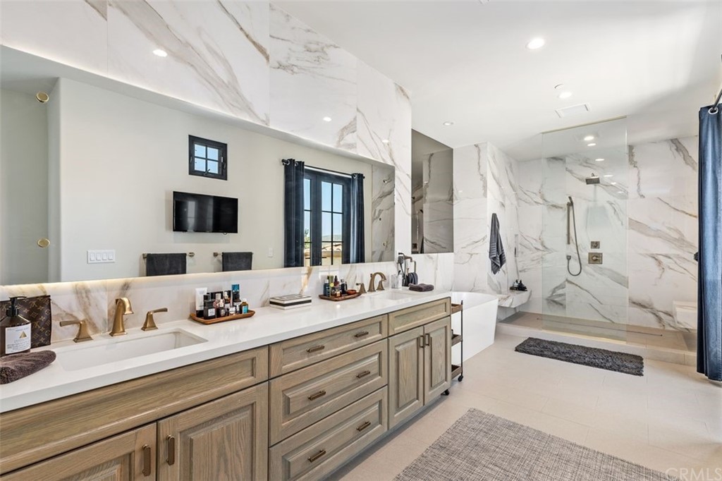 19 Alexa Lane Ladera Ranch, CA 92694 - Photo 20 of 40 a spacious bathroom with double vanity sinks a large mirror and a shower