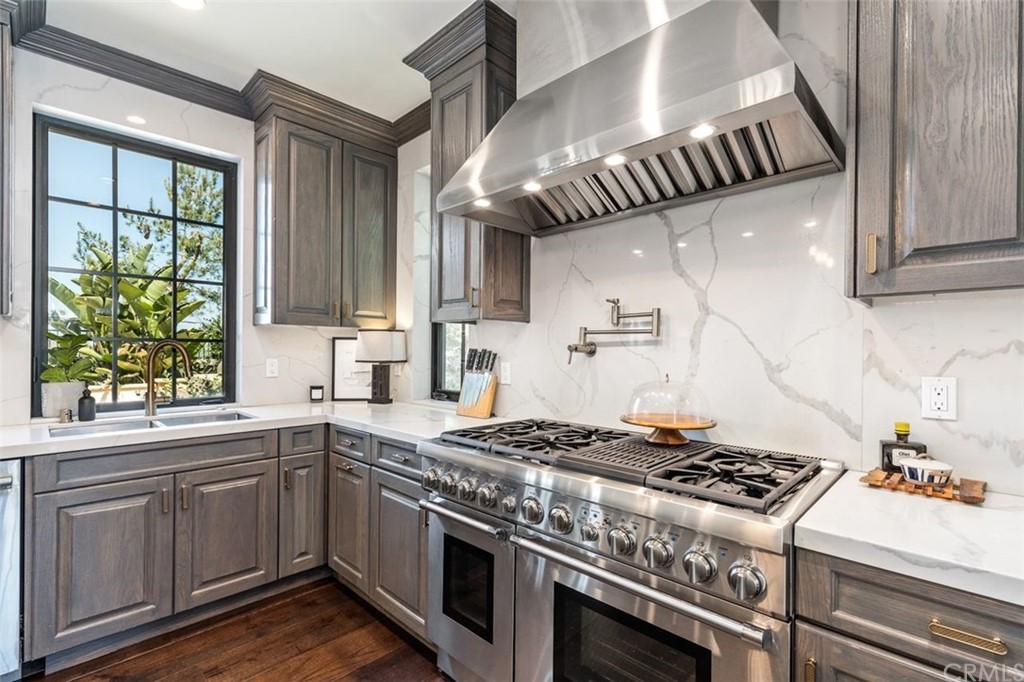 19 Alexa Lane Ladera Ranch, CA 92694 - Photo 32 of 40 a kitchen with stainless steel appliances granite countertop a stove a sink dishwasher and white countertops with wooden floor