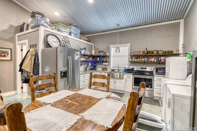 a kitchen with stainless steel appliances kitchen island granite countertop a refrigerator a stove and a sink