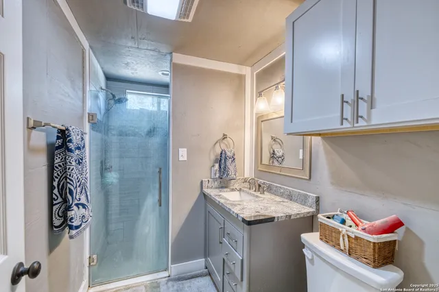 a bathroom with a granite countertop sink and a mirror
