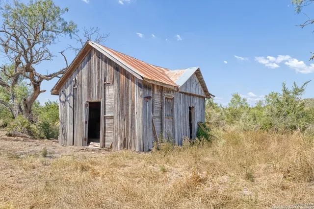 a view of a house with backyard and trees
