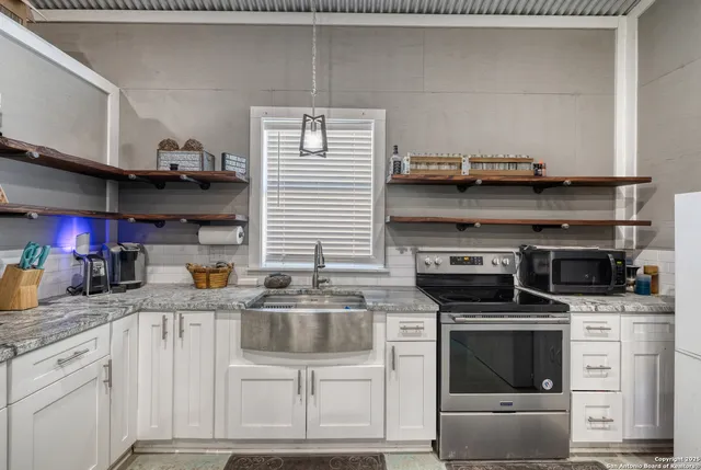 a kitchen with stainless steel appliances granite countertop a stove and a cabinets