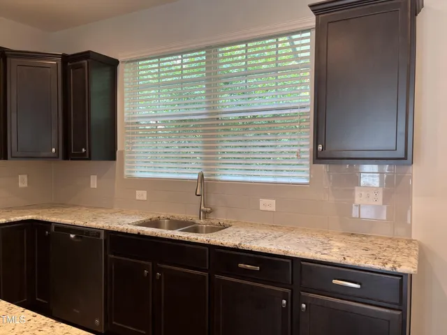 a kitchen with granite countertop cabinets sink and window