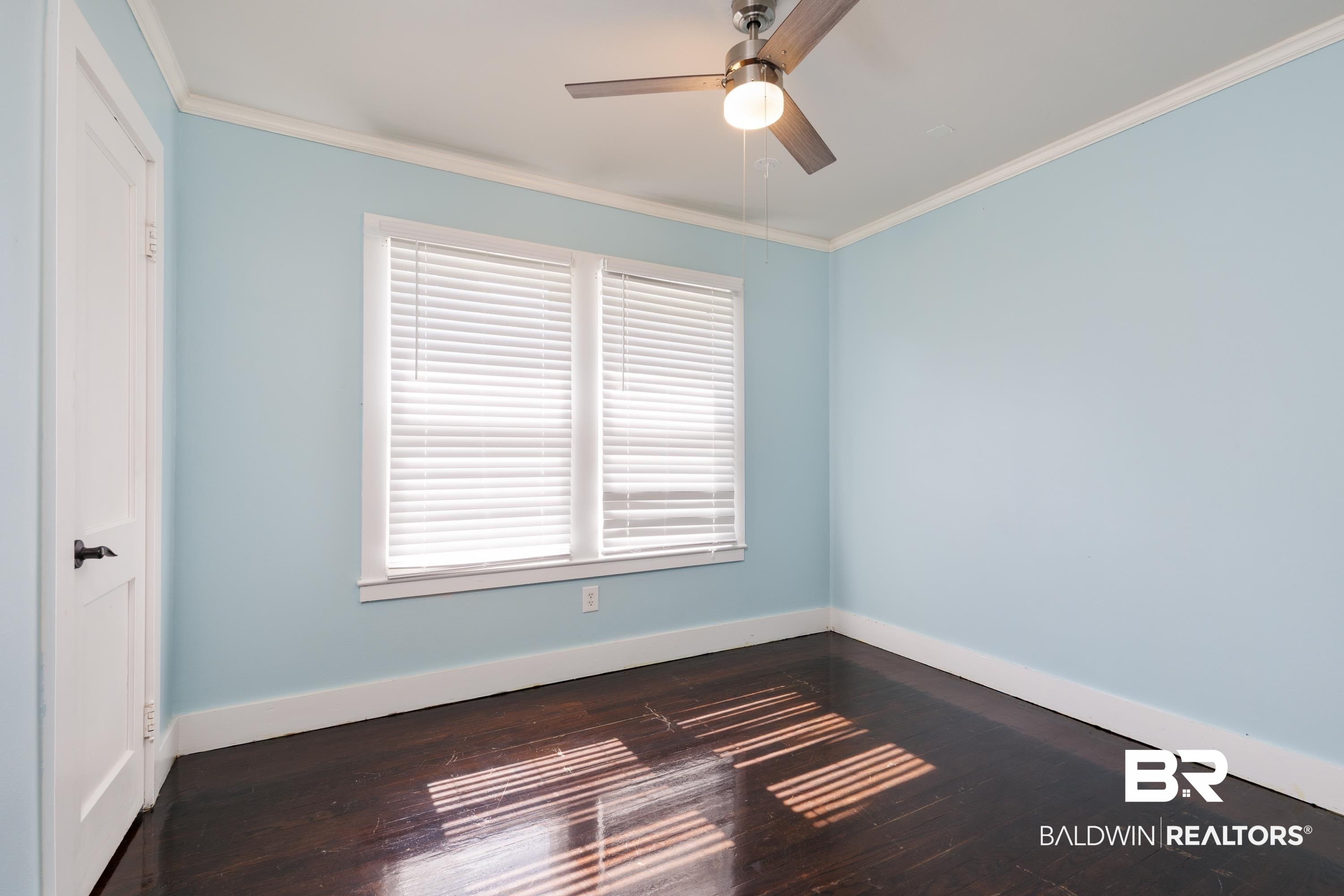 208 Beck Street Atmore, AL 36502 - Photo 21 of 26 Unfurnished room with ceiling fan, ornamental molding, wood finished floors, and plenty of natural light