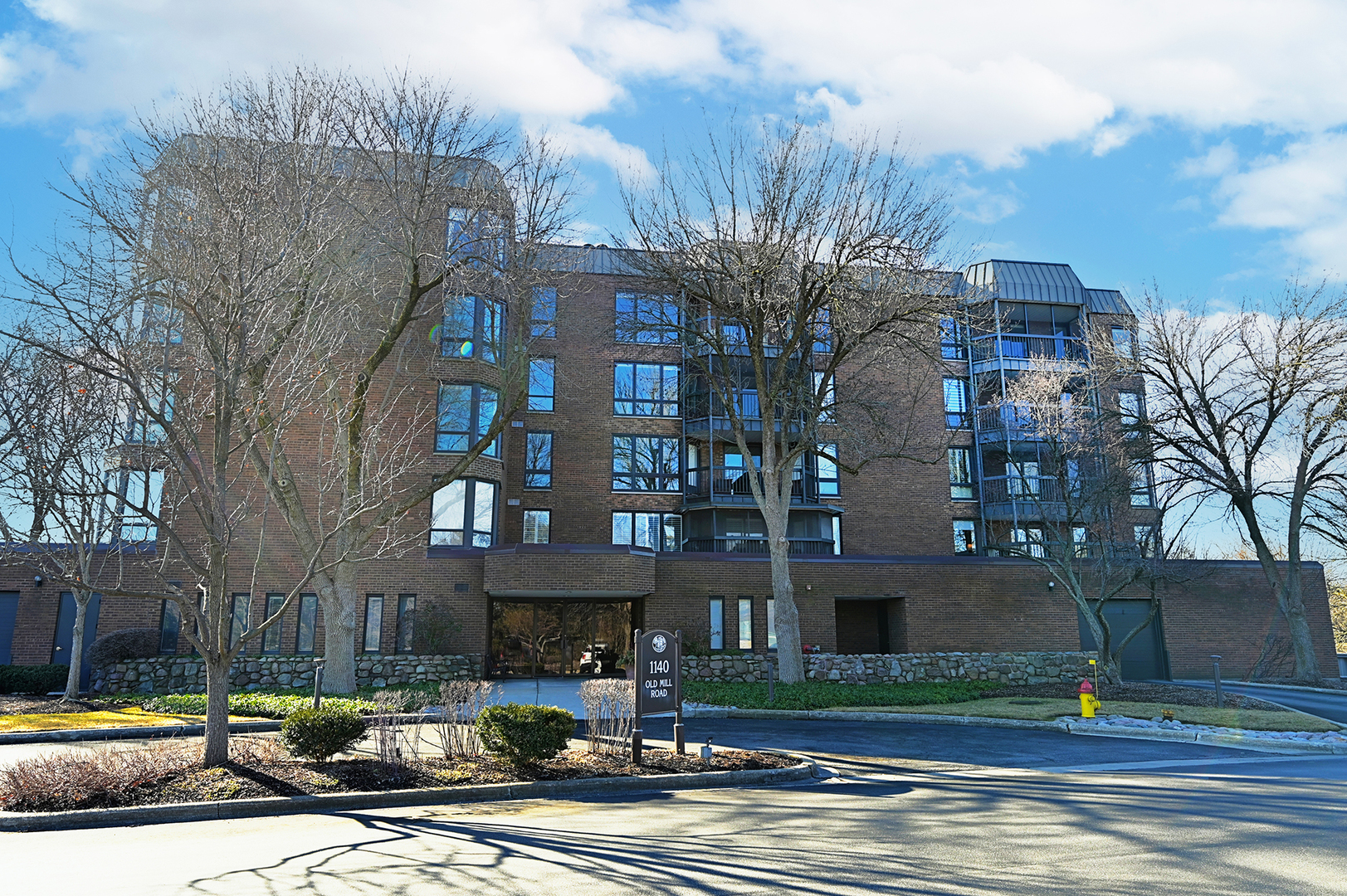 1140 Old Mill Road, Unit 101F Hinsdale, IL 60521 - Photo 1 of 14 a front view of a building with street view