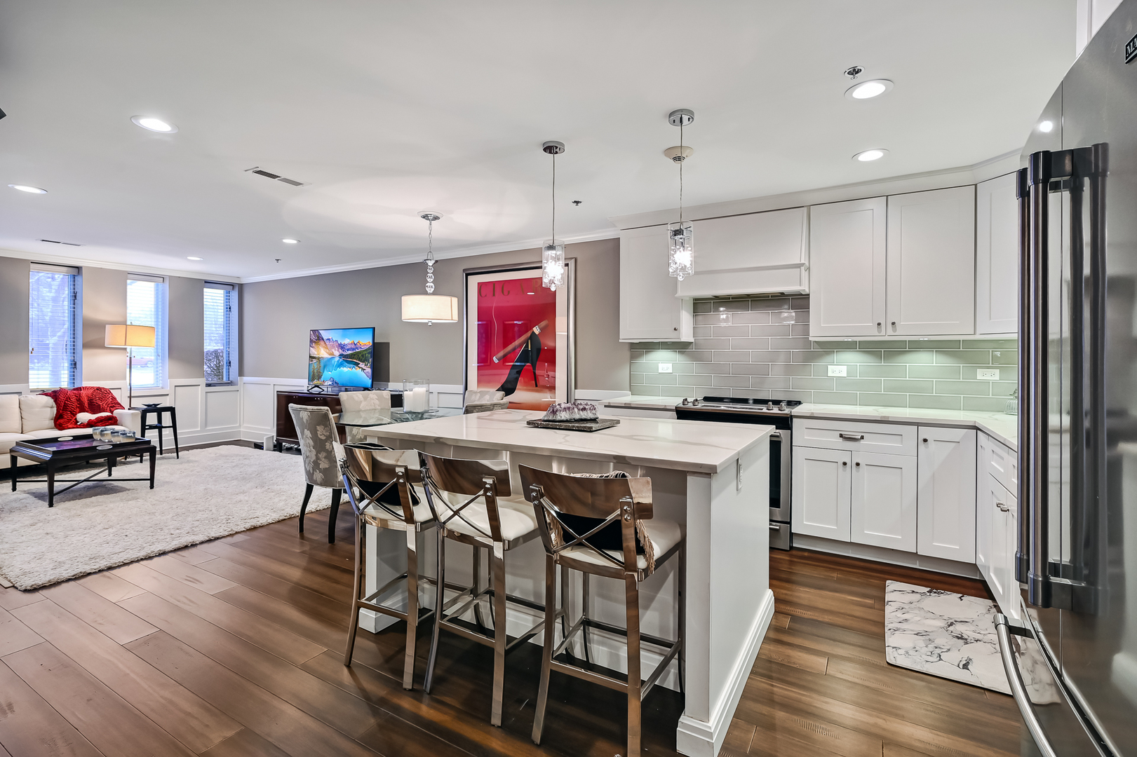 1140 Old Mill Road, Unit 101F Hinsdale, IL 60521 - Photo 4 of 14 a kitchen with stainless steel appliances granite countertop a stove top oven a refrigerator a sink and white cabinets with wooden floor