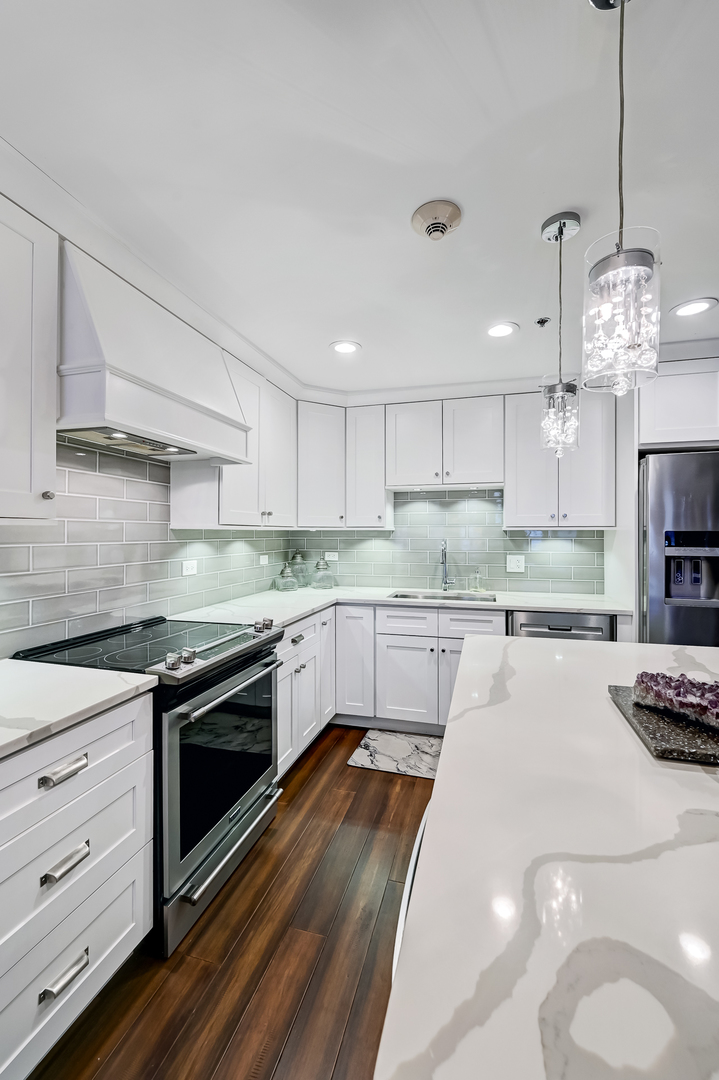 1140 Old Mill Road, Unit 101F Hinsdale, IL 60521 - Photo 6 of 14 a kitchen with stainless steel appliances granite countertop a sink a stove and a refrigerator