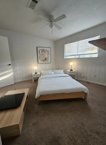 a bedroom with a bed couch and window