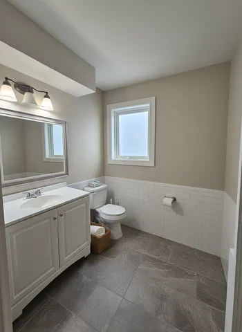 a bathroom with a toilet sink and mirror