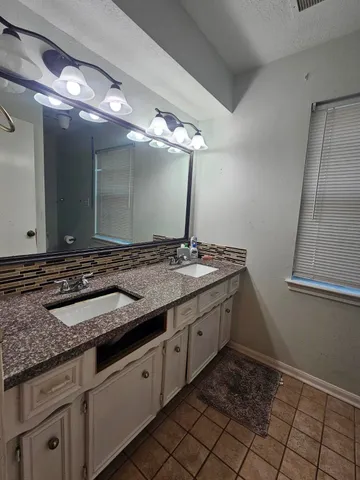 a bathroom with a granite countertop sink and a mirror