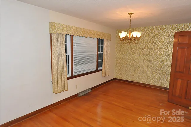 a view of a room with wooden floor and white walls