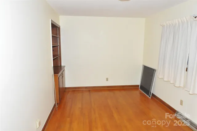 a view of a room with wooden floor and cabinet