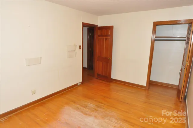 an empty room with wooden floor and closet