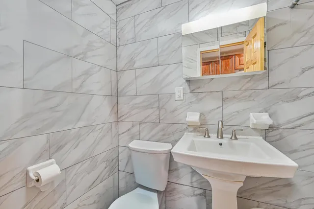 a bathroom with a sink mirror and toilet