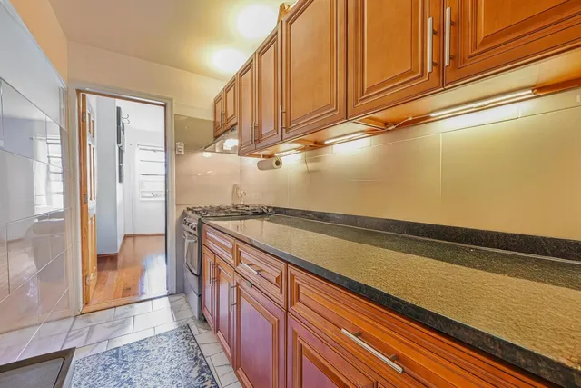 a view of a kitchen with wooden floor and cabinets