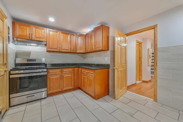 a kitchen with granite countertop a refrigerator and cabinets