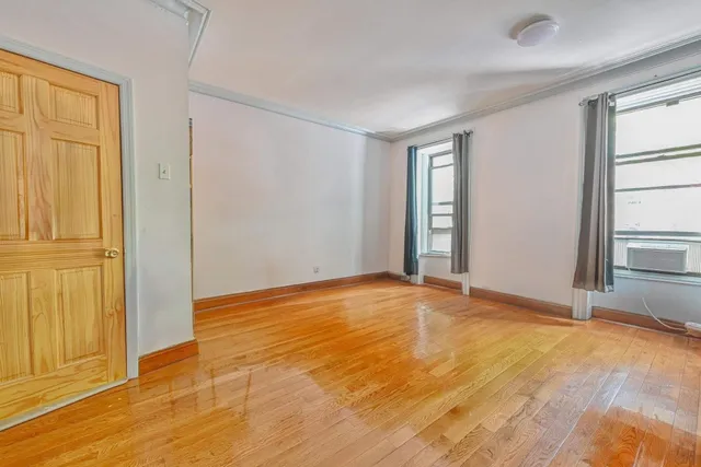 a view of an empty room with window and bathroom