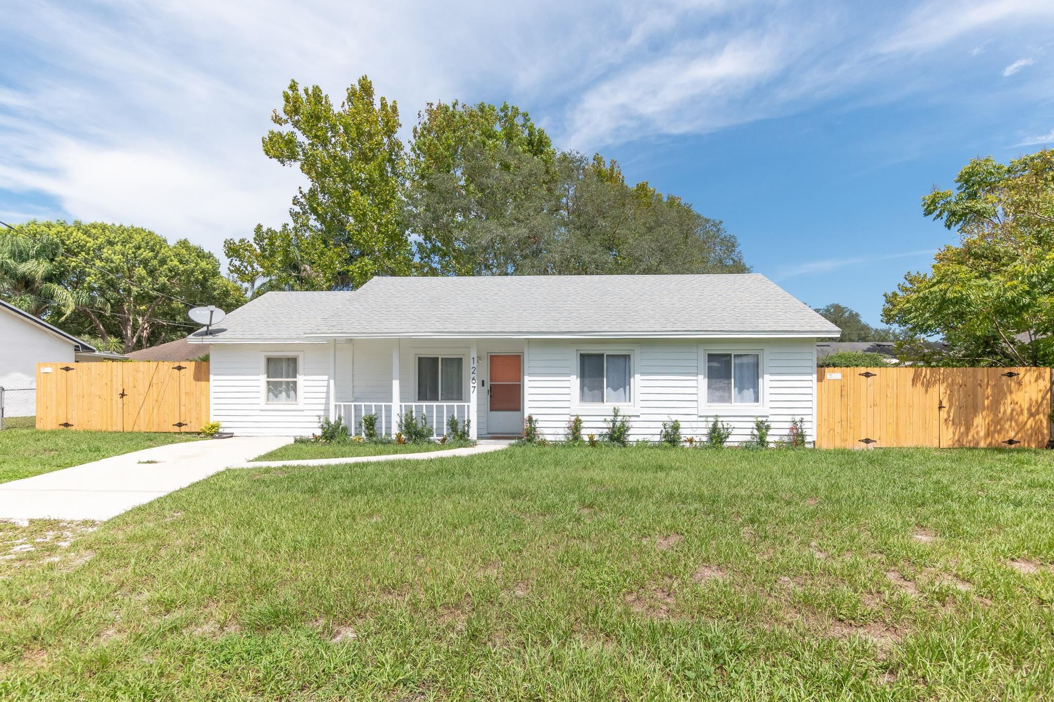 1267 Prince Road St. Augustine, FL 32086 - Photo 1 of 48 a front view of a house with a yard and trees